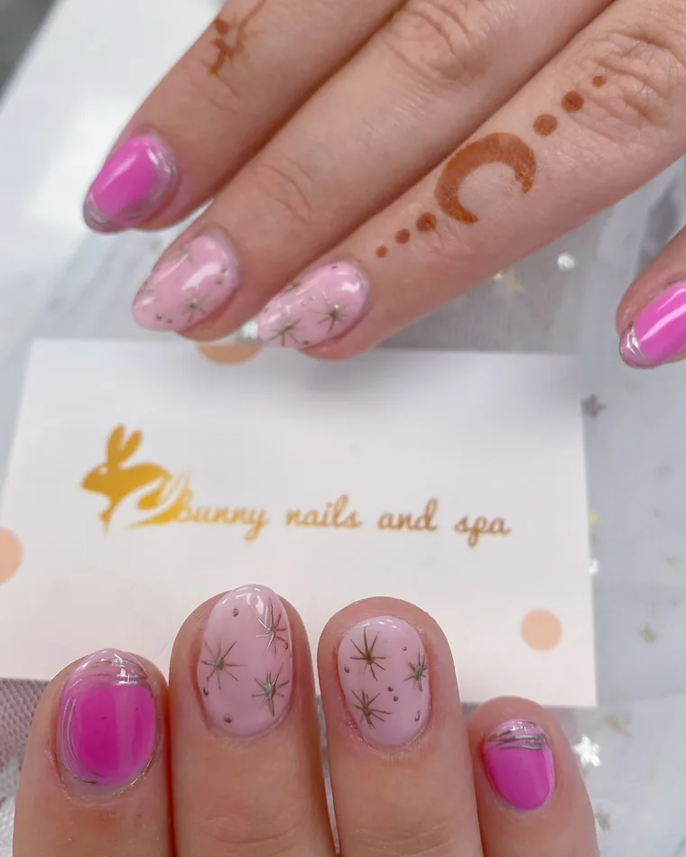 Short round nails in hot pink with silver starburst line art