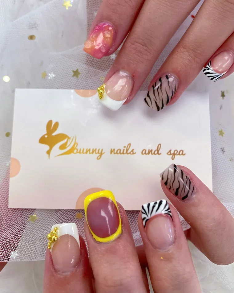 Short square nails with zebra tips, gold caviar beads and a yellow-framed accent