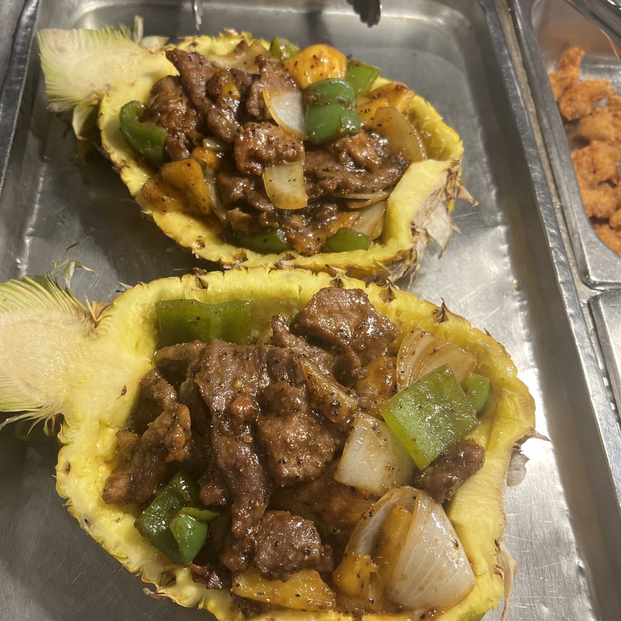Beef with peppers and onions served in pineapple halves