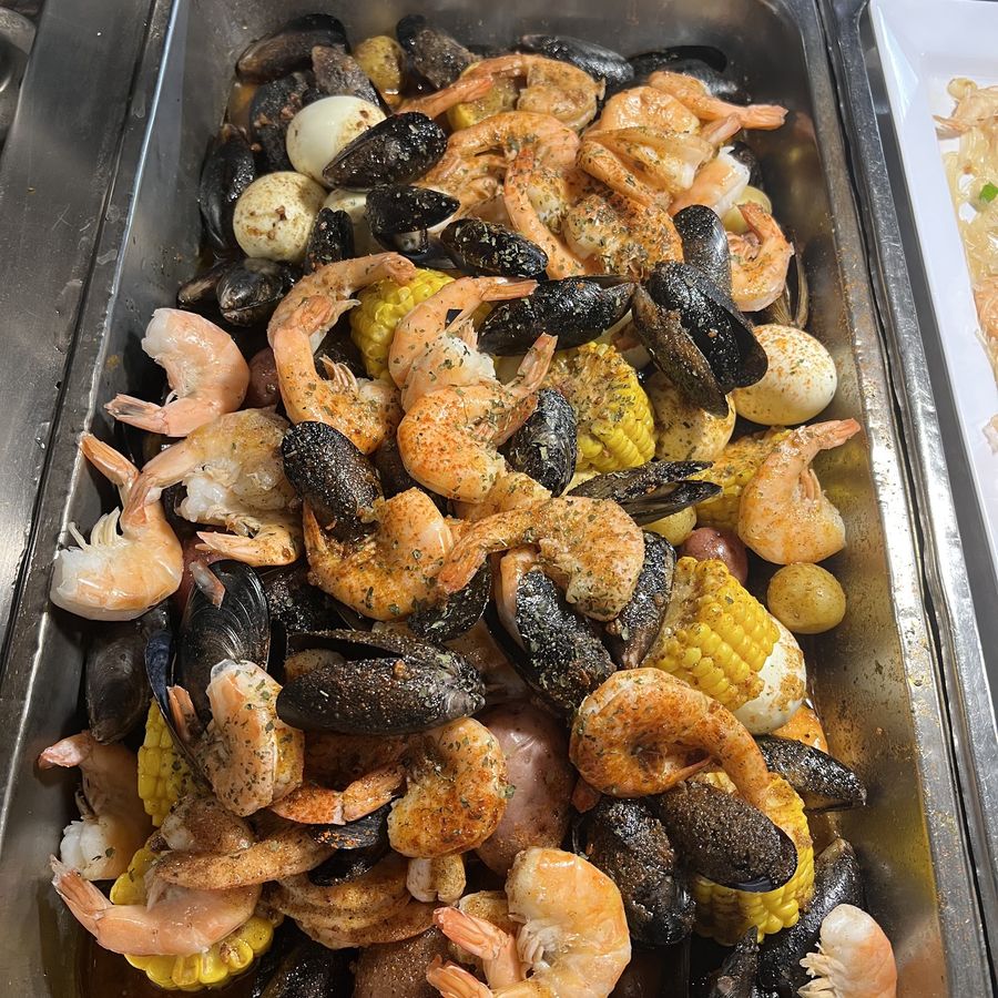 A tray of seafood boil: shrimp, mussels, corn, egg and potato