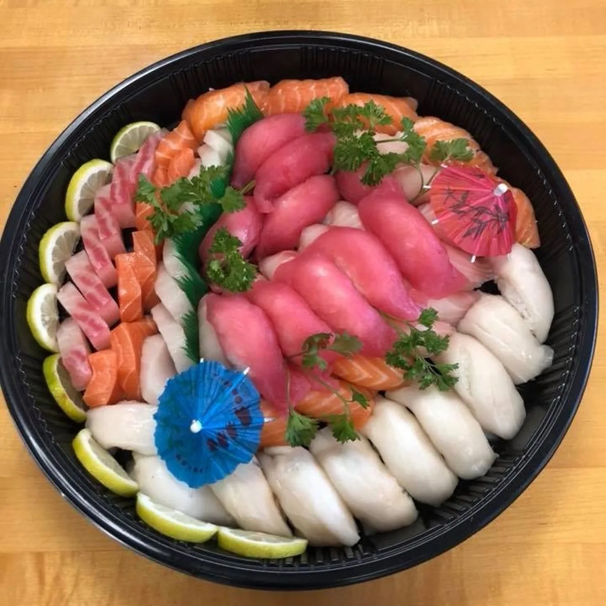 A round party tray of sushi and sashimi